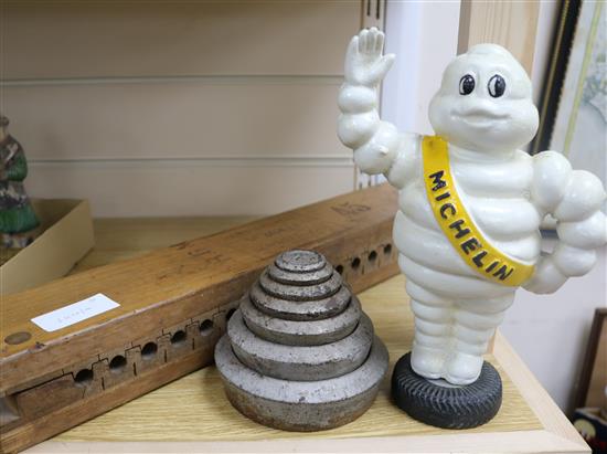 A painted cast iron Michelin figure, 23cm, a set of iron weights and a cigarette press